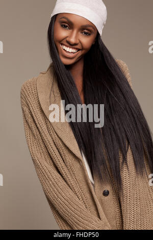 Long, dark haired woman wearing sweater and cap Stock Photo