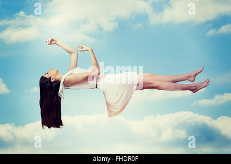 Composite image of girl in white dress floating in air Stock Photo