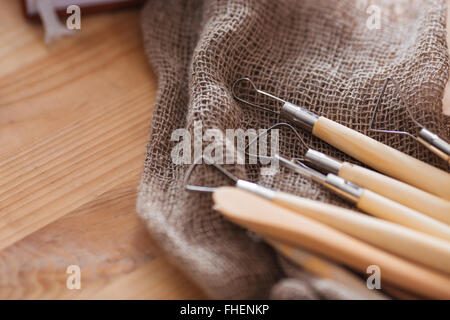 Closeup of set of craft scalpting tools for working with clay lying on wooden table Stock Photo