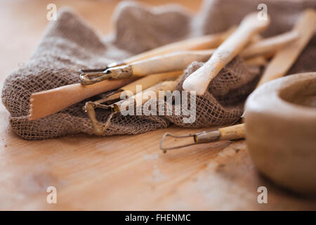 Set of dirty art and craft sculpting tools on wooden table in pottery workshop Stock Photo