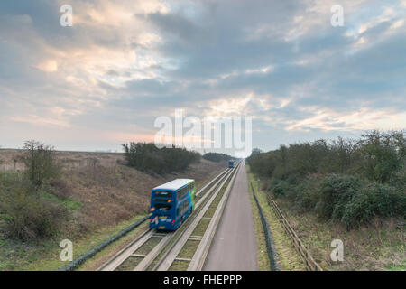 Cambridgeshire, UK. 25th February, 2016. There was a cloudy and overcast start to the day on the guided busway on the outskirts of the village of Over in Cambridgeshire and the weather was warmer than forecast. Instead of the forecast sharp frost, cloud cover kept temperatures just over freezing as buses headed towards Cambridge. Credit: Julian Eales/Alamy Live News Stock Photo