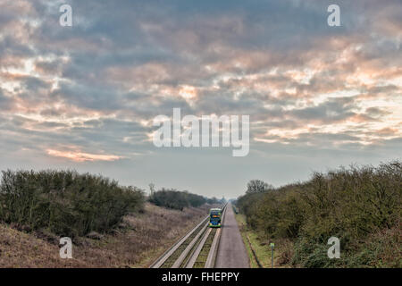 Cambridgeshire, UK. 25th February, 2016. There was a cloudy and overcast start to the day on the guided busway on the outskirts of the village of Over in Cambridgeshire and the weather was warmer than forecast. Instead of the forecast sharp frost, cloud cover kept temperatures just over freezing as buses headed towards Cambridge. Credit: Julian Eales/Alamy Live News Stock Photo