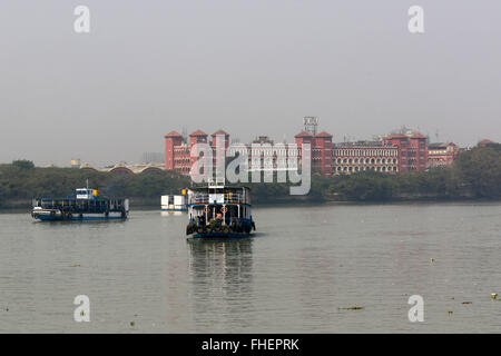 Calcutta, India 18 February 2016.Shuttle ferry crossing the Hooghly River. On the background the Howrah railway station. Calcutta (Kolkata).Photo by Palash Khan Stock Photo