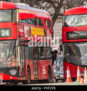 Man leaning out of London bus Stock Photo