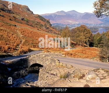 View of Ashness Bridge over Barrow Beck with Derwent Water to the rear, Near Keswick, Borrowdale, Lake District, Cumbria, UK. Stock Photo