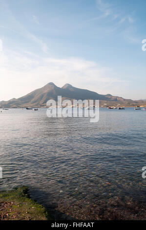 The volcanos of El Fraile and El Fraile Chico with small fishing boats and Bateria de San Felipe at Los Escullos, Cabo de Gata Stock Photo