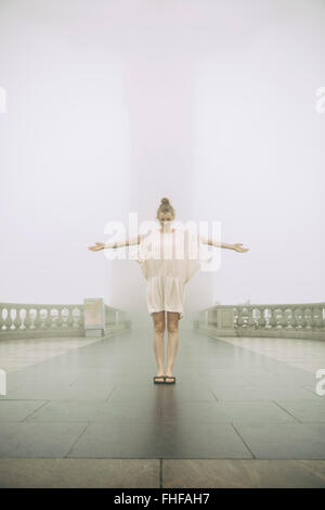 Brazil, Rio de Janeiro, woman impersonating Christ the Redeemer on a hazy day Stock Photo
