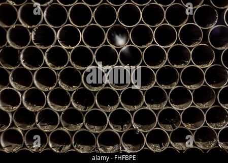 close-up of an array of round pipes, stacked upon each other, with file dust remnants on them Stock Photo