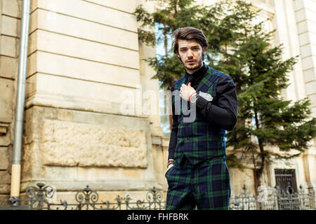 elegant man standing outside, wearing green plaid costume Stock Photo