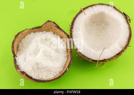 Coconut powder in coconut shell and fresh coconut on green background Stock Photo