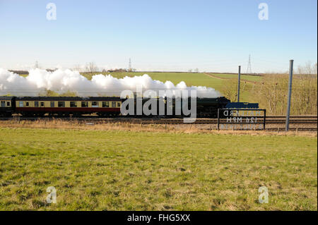 Essendine, UK. 25th February, 2016. The Flying Scotsman on it's inaugural trip from London Kings Cross to York after it's 10 year re-fit passing the Mallard sign near Stoke Bank in the Lincolnshire Countryside. Credit:  Jonathan Clarke/Alamy Live News Stock Photo