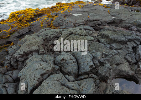 Fragment of black rocky volcanic shore Stock Photo