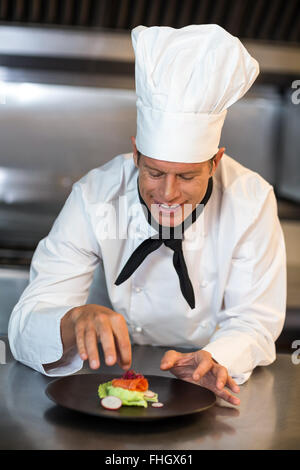 Happy chef garnishing his dish Stock Photo