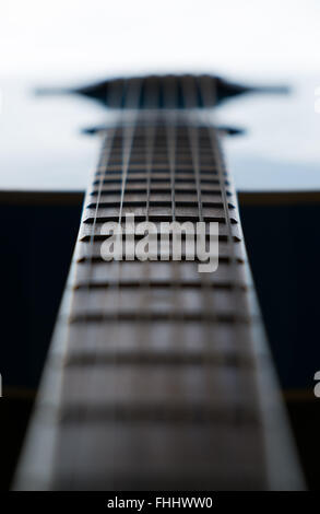 Detail of wooden acoustic guitar frets on a blue guitar back lit and shot with selective focus Stock Photo