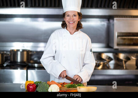 Chef Chopping Vegetables On A Wooden Cutting Board Stock Photo, Picture and  Royalty Free Image. Image 32124885.