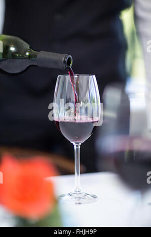 Waiter pouring a glass of red wine Stock Photo