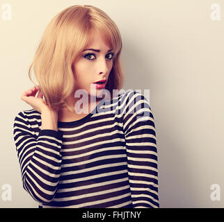 Unhappy blond woman with short hairstyle surprising from bad news. Closeup toned portrait Stock Photo