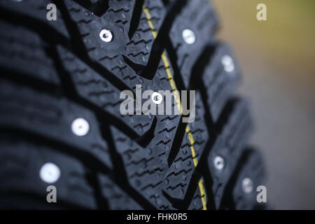 Studded tire on a gray background Stock Photo