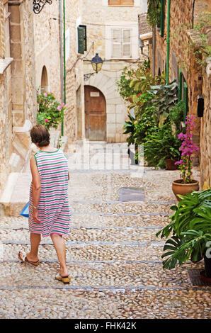 Mallorca, Balearic Islands, Spain: a woman walks in a street in Fornalutx, a mountainous municipality in the Soller district Stock Photo
