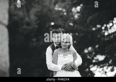 Beautiful wedding couple hugging in the park Stock Photo
