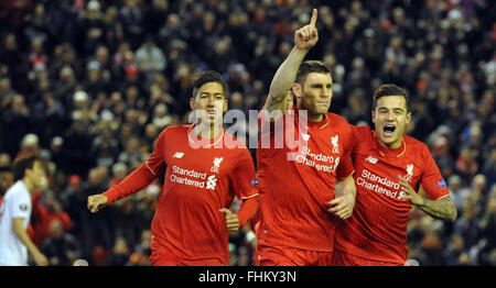 Liverpool, UK. 25th February, 2016. Liverpool's Roberto Firmino (L-R), James Milner und Philippe Coutinho celebrate after Milner scored the opening goal during the UEFA Europa League round of 32, second leg soccer match between Liverpool FC and FC Augsburg in Anfield, Liverpool, England, on 25 February 2016. Credit:  dpa picture alliance/Alamy Live News Stock Photo