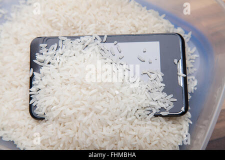 Using uncooked rice to draw out moisture from a mobile phone Stock ...
