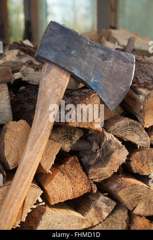 Wooden axe resting on some split firewood. Stock Photo