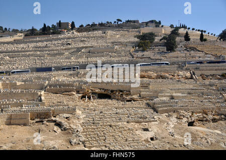 Tour buses and tombs in the Jewish cemetery of the  Mount of Olives, Jerusalem, Israel Stock Photo