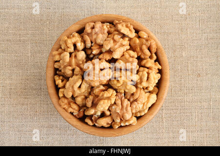 Big shelled walnuts in bamboo bowl on rough linen cloth Stock Photo