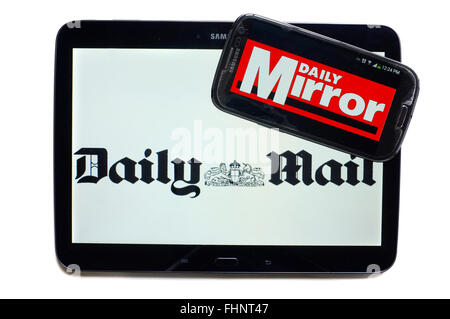 The logos of the Daily Mail and the Daily Mirror newspapers displayed on the screens of a tablet and a smartphone. Stock Photo