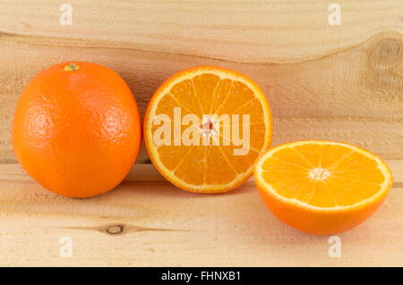 Whole and sliced oranges on green background Stock Photo