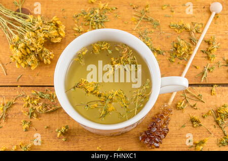 St Johns wort tea and surrounded by dried kantarion plants Stock Photo
