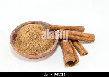 Grounded and whole cinnamon sticks in two shapes on white background Stock Photo