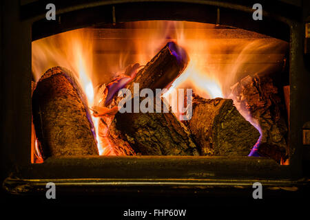 Old fireplace with a burning firewoods Stock Photo