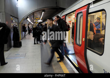 Commuters people getting off a London underground tube train carriage stepping onto a platform at an underground station in England UK  KATHY DEWITT Stock Photo