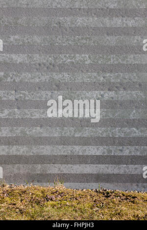 Striped stone wall and grass background Stock Photo