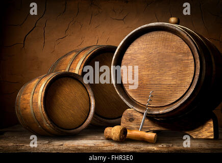 Wooden barrels and corkscrew in clay cellar Stock Photo