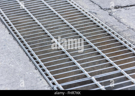 Black and white close up of a sidewalk subway grate with shallow depth of field. Stock Photo