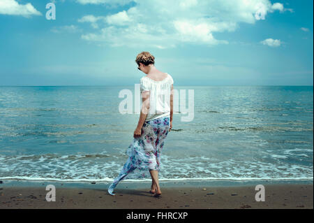 young woman walking on the beach Stock Photo