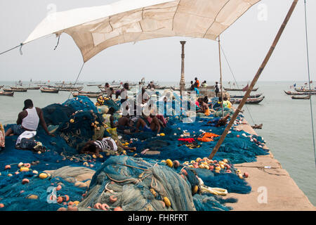 ACCRA, GHANA - JANUARY 2016: Fishermen preparing their nets on the pier of Jamestown, Accra, Ghana Stock Photo