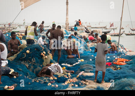 ACCRA, GHANA - JANUARY 2016: Fishermen preparing their nets on the pier of Jamestown, Accra, Ghana Stock Photo