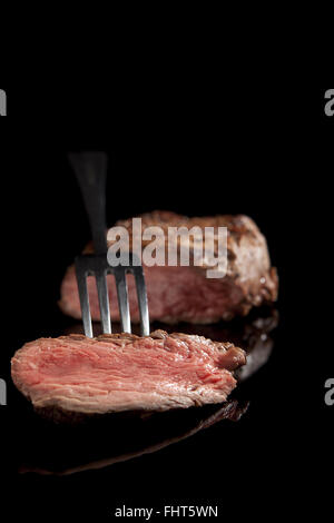 Medium rare, sliced rib eye steak, grilled cowboy steak, on a chopping