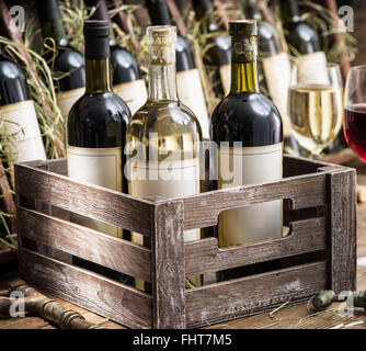 Old wine bottles in a wooden crate. Stock Photo