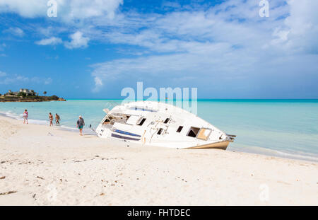 Wrecked yacht abandoned and disintegrating on the beach in Dickenson Bay, north Antigua, Antigua and Barbuda, West Indies Stock Photo
