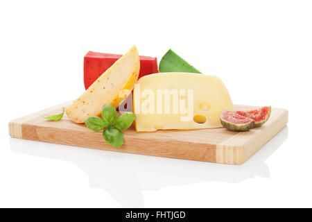 Colorful cheese assortment on chopping board. Stock Photo