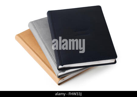 Pile of leather hardcover business diaries isolated on white background. Black, gray and beige notebooks Stock Photo