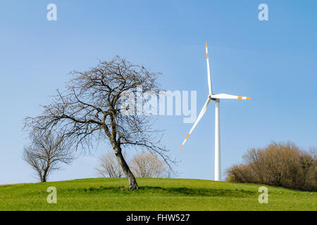 Wind turbine installed on a green hill. Stock Photo