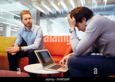 Business colleagues relaxing on sofa during break Stock Photo