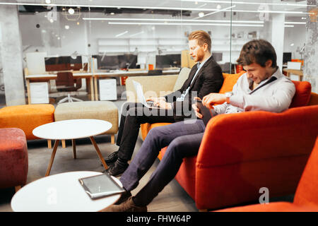 Businesspeople working while looking at devices and  laptops Stock Photo