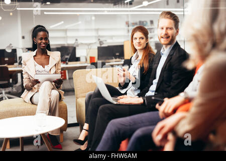 Business people conversation with technology at hand. Exchange of new ideas and brainstorming between colleagues Stock Photo